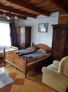 a bedroom with a wooden bed and a chair at Bableves Vendégház in Felsőtold