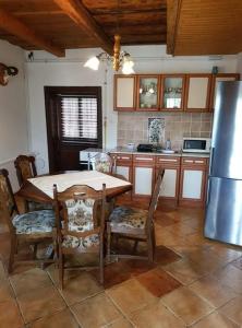 a kitchen with a table and chairs and a refrigerator at Bableves Vendégház in Felsőtold