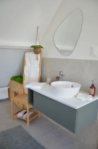 a bathroom with a white sink and a chair at Zennon in Geraardsbergen