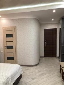 1 dormitorio con 1 cama y pasillo con puerta en SM Apartment en Ereván