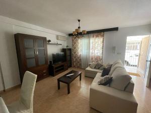 a living room with a couch and a tv at Casa Moraira in Águilas