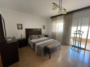 sypialnia z łóżkiem i dużym oknem w obiekcie Casa Moraira w mieście Águilas