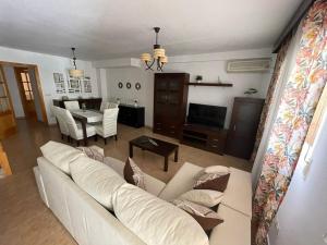 sala de estar con sofá blanco y mesa en Casa Moraira, en Águilas