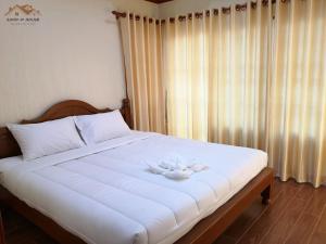 a large white bed with a white flower on it at Sand-D House Pool Villa A13 at Rock Garden Beach Resort Rayong in Mae Pim