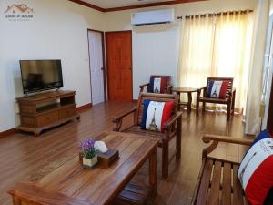 uma sala de estar com mobiliário em madeira e uma televisão de ecrã plano em Sand-D House Pool Villa A13 at Rock Garden Beach Resort Rayong em Mae Pim