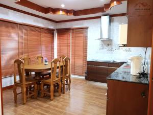 uma cozinha com uma mesa de madeira e cadeiras em Sand-D House Pool Villa A13 at Rock Garden Beach Resort Rayong em Mae Pim