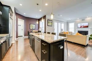 a kitchen with a counter top and a living room at Lux 5BD - Theater, Gym, Game Room, Parking & more! in Ashburn