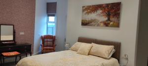a bedroom with a bed and a mirror and a chair at Fishtail House - Stylish Apartments minutes from the sea in Hornsea