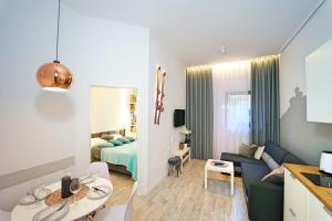 カルパチにあるApartamenty EverySky - Prusa 2A - przyziemieのベッドルームとリビングルームが備わる小さなアパートメントです。