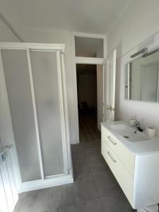 Baño blanco con lavabo y espejo en CHECK-IN CASAS Casa Aurora en Benasque
