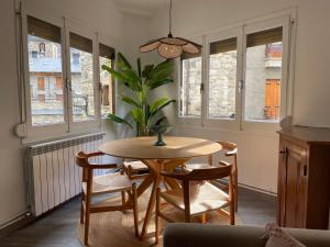 a dining room with a table and chairs and windows at CHECK-IN CASAS Casa Aurora in Benasque