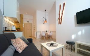 ein Wohnzimmer mit Sofa und Tisch in der Unterkunft Apartamenty EverySky - Prusa 2A - przyziemie in Karpacz