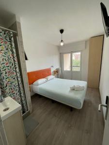 Habitación pequeña con cama y ventana en Pensión La Estrella en Zaragoza