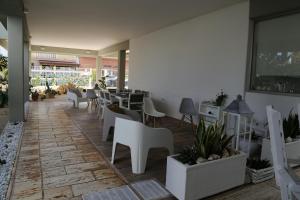a restaurant with white chairs and tables and plants at Virò House in Squinzano