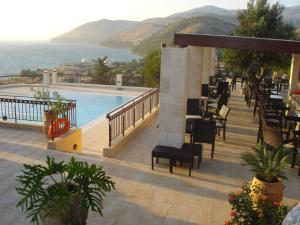 a resort with a pool and tables and chairs at NorthWest Studios in Argostoli