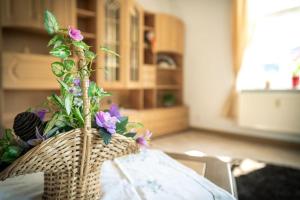 a basket with flowers on top of a table at Ferienwohnung-Loebau-Messe-und-Zentrumsnah in Löbau