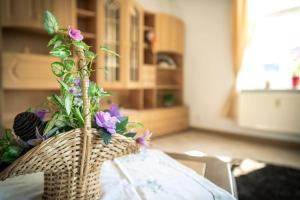 a basket with flowers on top of a table at Ferienwohnung-Loebau-Messe-und-Zentrumsnah in Löbau +10 photos
