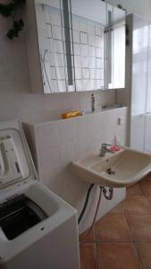 a white bathroom with a sink and a mirror at Ferienwohnung-Loebau-Messe-und-Zentrumsnah in Löbau