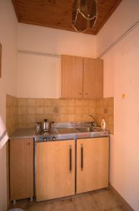 a kitchen with wooden cabinets and a sink at NorthWest Studios in Argostoli