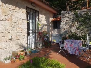a patio with a table and chairs in front of a stone building at IL NIDO DI KIKI Affittacamere BIKE &FUN in Finale Ligure