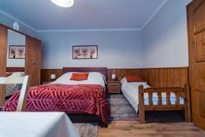 Un dormitorio con 2 camas y una silla. en Estike Apartman, en Gyula