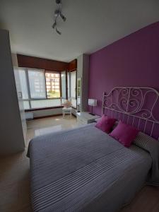 een paarse slaapkamer met een groot bed met paarse muren bij Apartamento Noja Beach in Noja