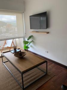 a living room with a coffee table and a flat screen tv at Sarmiento Suites Premium in Salta