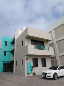 a white car parked in front of a building at Penghu Dayou View B&B in Magong