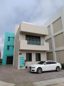 a white car parked in front of a house at Penghu Dayou View B&B in Magong