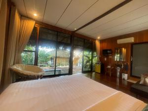 a bedroom with a large bed and a large window at บ้านริมเลปากประ Banrimlay Pakpra in Phatthalung