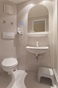 a white bathroom with a toilet and a sink at Landgasthof Zum Schützenhaus Sosa in Eibenstock