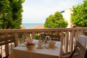 una mesa con 2 tazas y un bol de fruta en el balcón en B&B Viale Italia 22, en Follonica