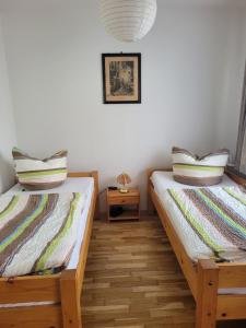 two twin beds in a room with a table at Ferienwohnung Familie Klingohr in Erfurt