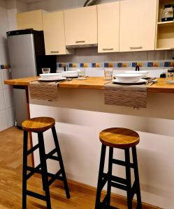 a kitchen with two bar stools at a counter at El Rinconcito de la Merced in Toledo
