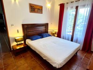 ein Schlafzimmer mit einem Bett mit zwei Lampen und zwei Fenstern in der Unterkunft Villa Le Refuge du Pirate in Deshaies