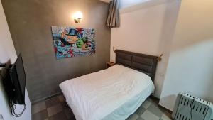 um pequeno quarto com uma cama e uma fotografia na parede em SPACE ART BOUTIQUE Downtown em Jerusalém