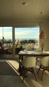 une salle à manger avec une table, des chaises et une grande fenêtre dans l'établissement SunBeach Apartment with seaview and sauna, à Kalajoki