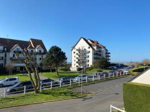 a parking lot with cars parked on the side of a road at Cabourg T2 cosy avec accès direct plage in Cabourg