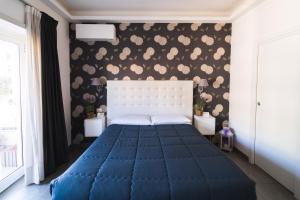1 dormitorio con 1 cama con colcha azul en RomAntic Dreams Guest House, en Roma