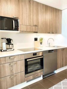 a kitchen with a stainless steel oven and a sink at SunBeach Apartment with seaview and sauna in Kalajoki