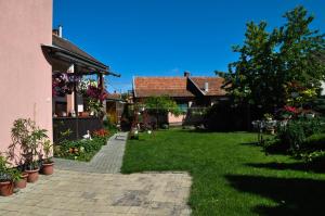 a yard with a house and a garden with a ladder at Lugas Szallas in Jászberény