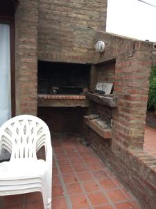 a white chair sitting next to a brick oven at Complejo Casa Clara in Santa Clara del Mar