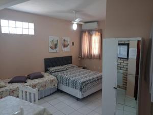 1 dormitorio con 2 camas y ventana en Apartamento, en Florianópolis