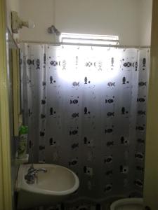 Un baño con una cortina de ducha con perros. en Chalet en Punta Mogotes - Sólo Familias - NO se aceptan grupos de jóvenes, en Mar del Plata