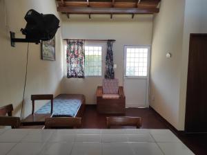 a living room with two chairs and a couch and windows at Casas Vacacionales La Cima in Mérida