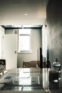 a living room with a glass table and a window at Dealhouse-Apartments 5 in Huddersfield