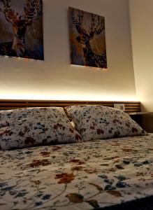 a bedroom with a bed with two paintings on the wall at El Rinconcito de la Merced in Toledo