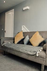 um sofá com almofadas na sala de estar em Dealhouse-Apartments 5 em Huddersfield