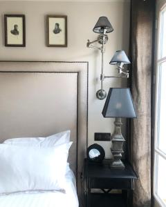 a bedroom with a bed and a lamp on a night stand at Hotel Saint-Louis en L'Isle - Notre-Dame in Paris