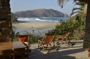 two chairs and a table on a beach at The Lodge on the Beach in Port St Johns